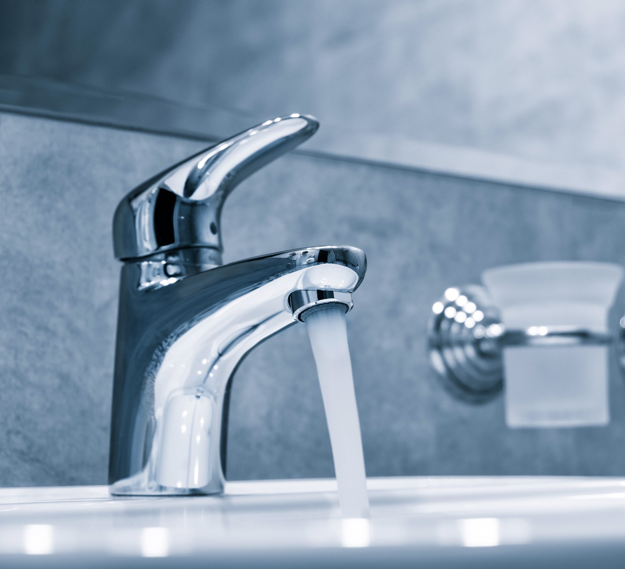 Water tap, faucet. Flow water in bathroom with sink. Modern clean hause. Hygiene concept.